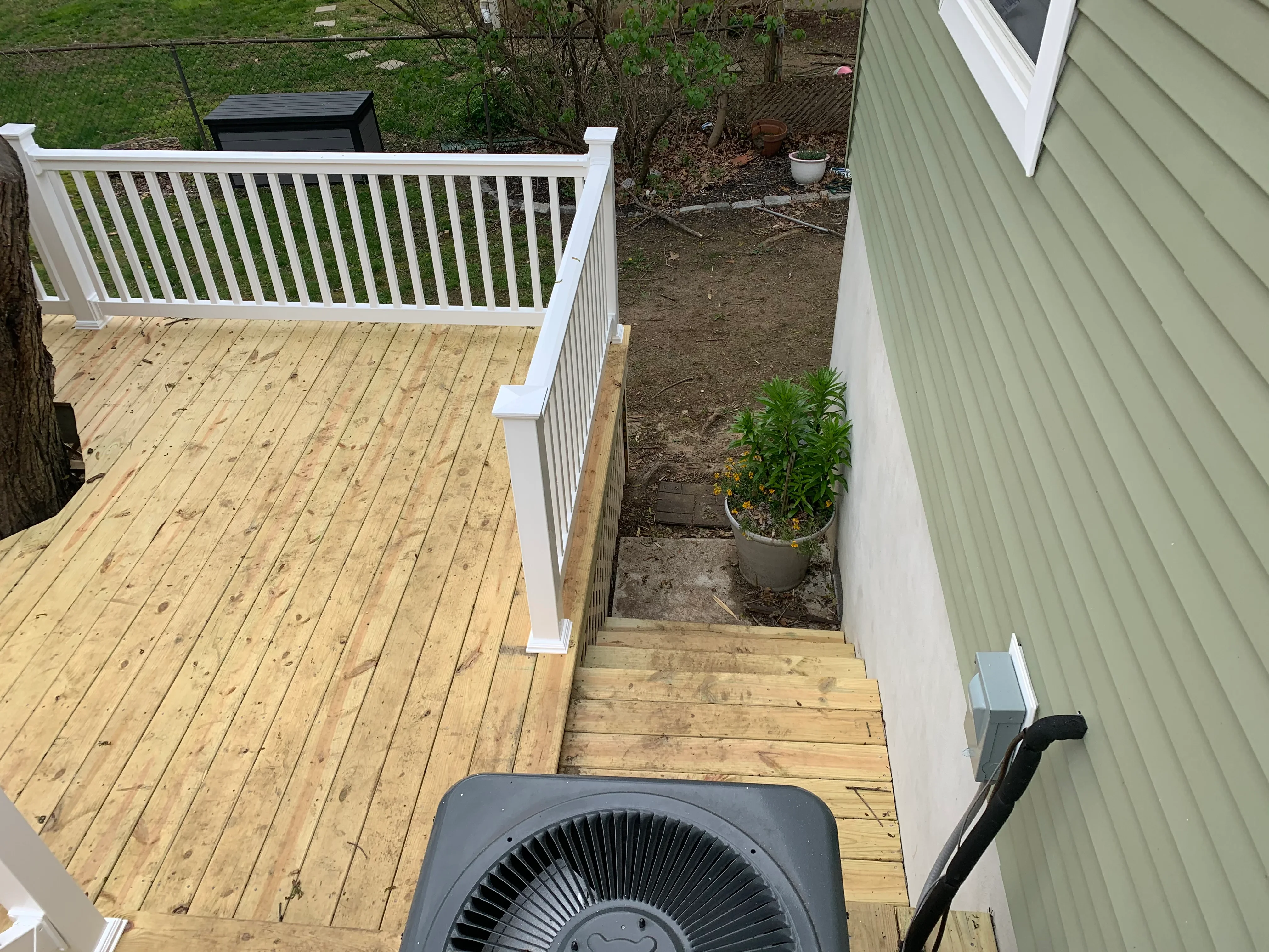 Pressure-treated deck with white vinyl railing and stairs, new construction