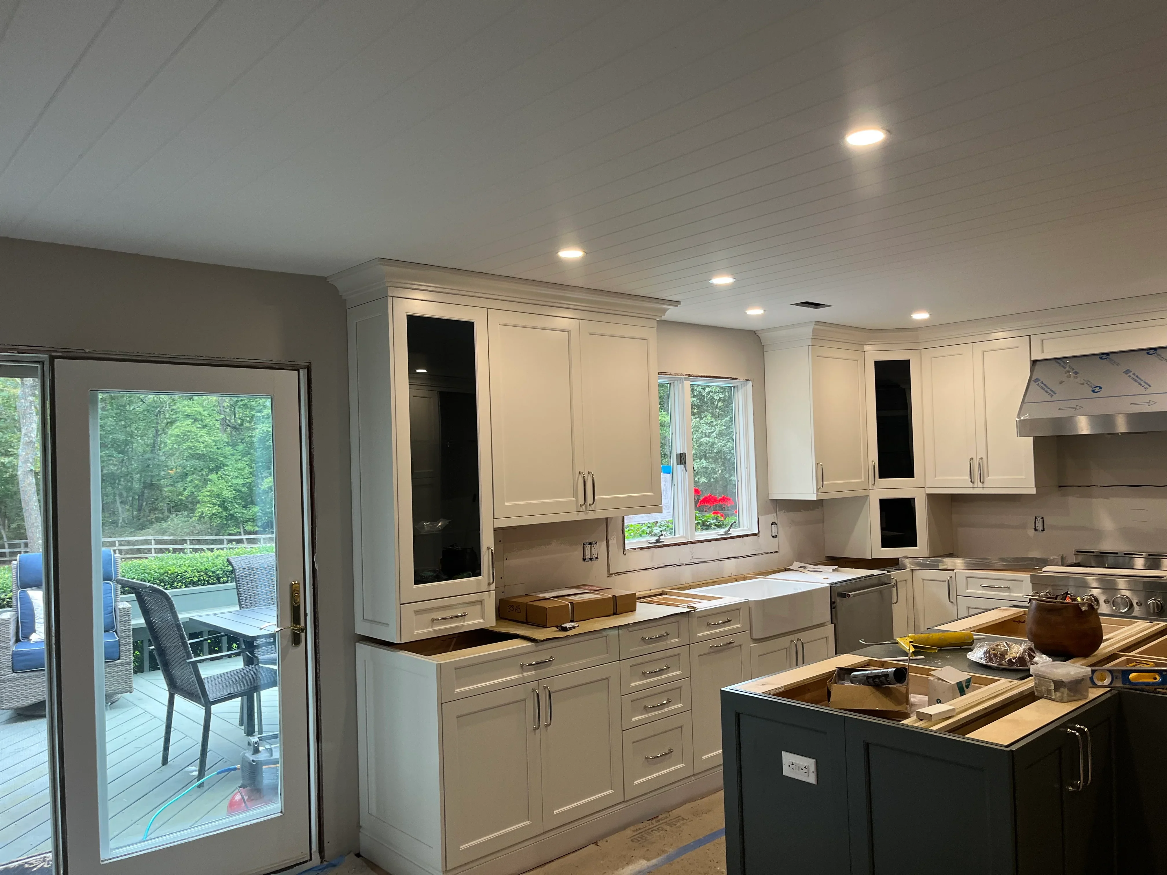 Kitchen with cream cabinetry, dark island, quartz counters, and stainless steel appliances