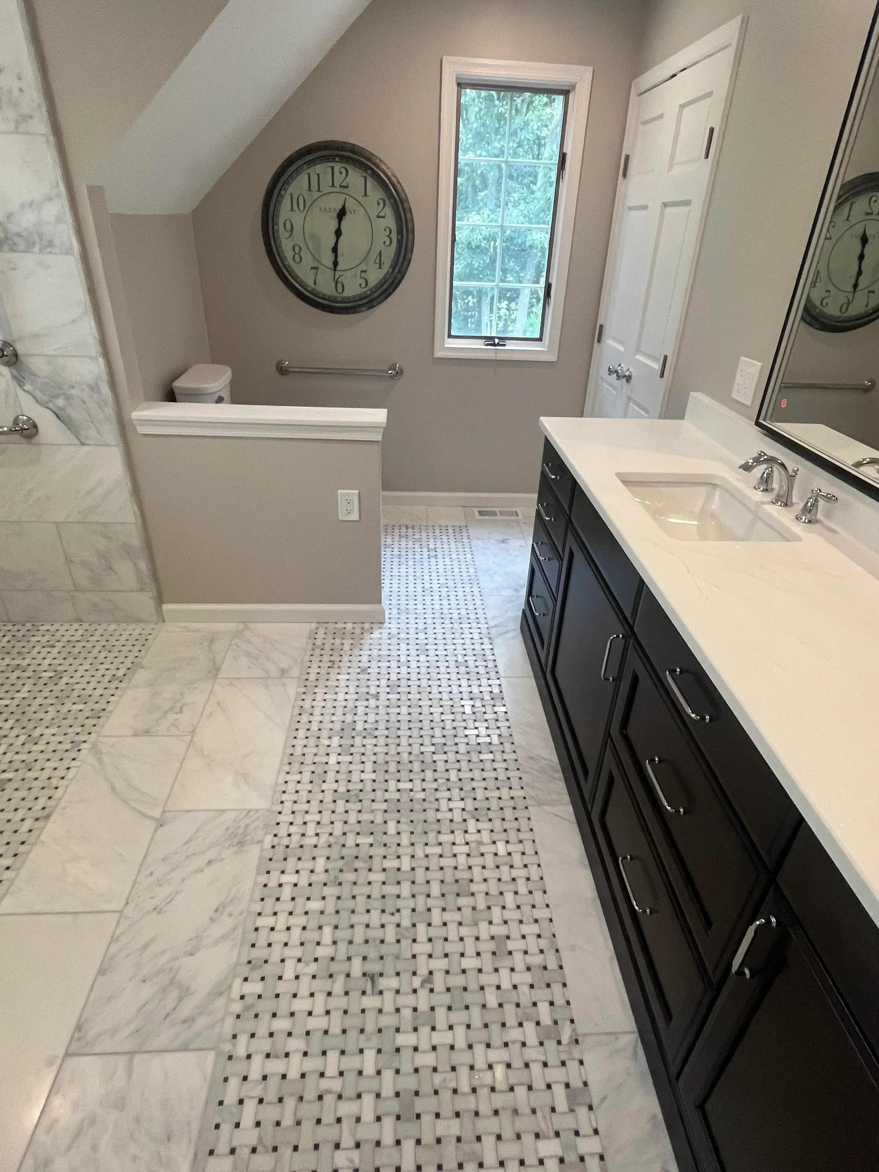 Kitchen with marble subway tile backsplash, mosaic accent tiles, black range hood, white cabinets, and stainless steel hardware