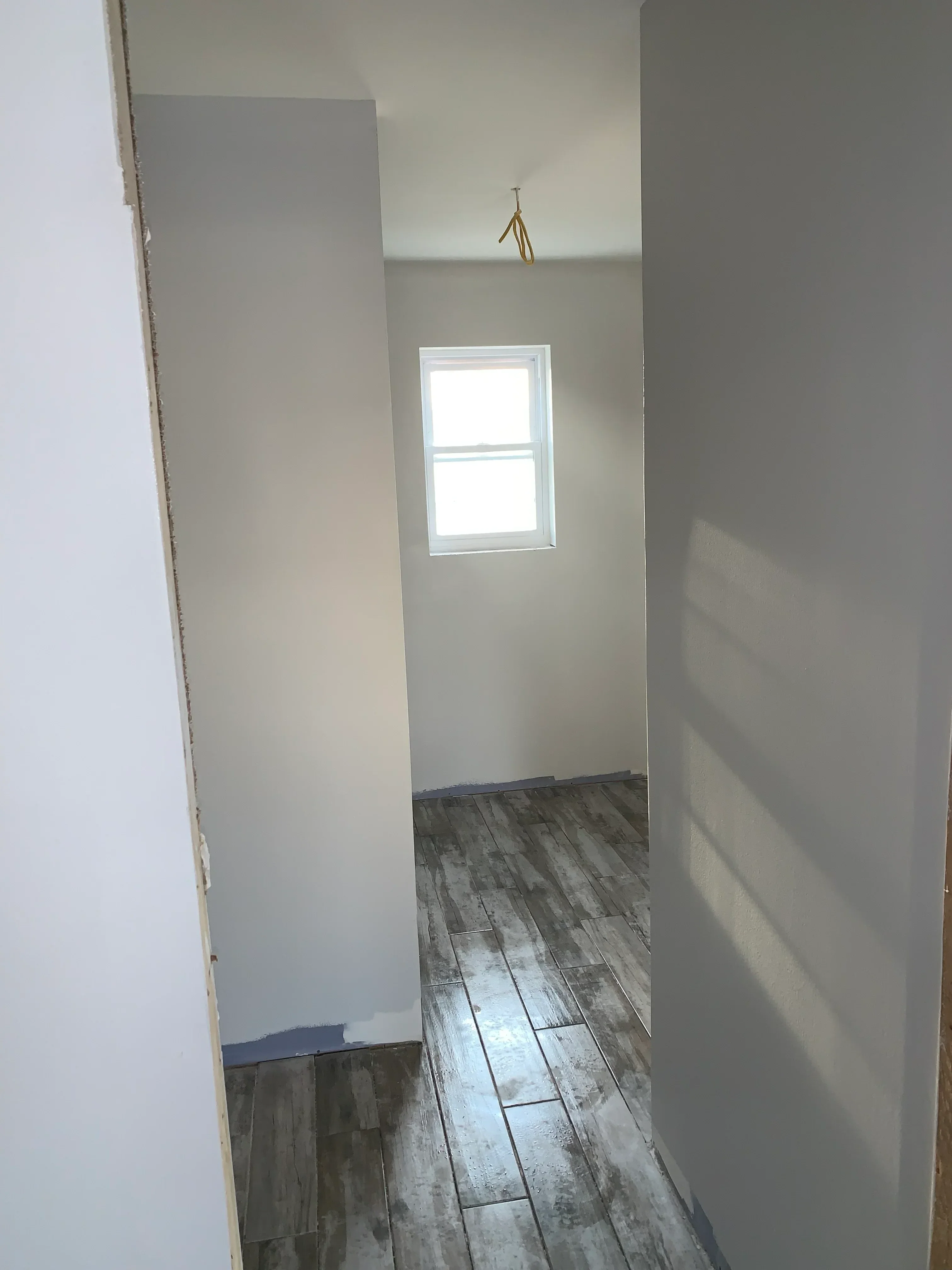 Drywall installation with wood shiplap accent wall and recessed window opening