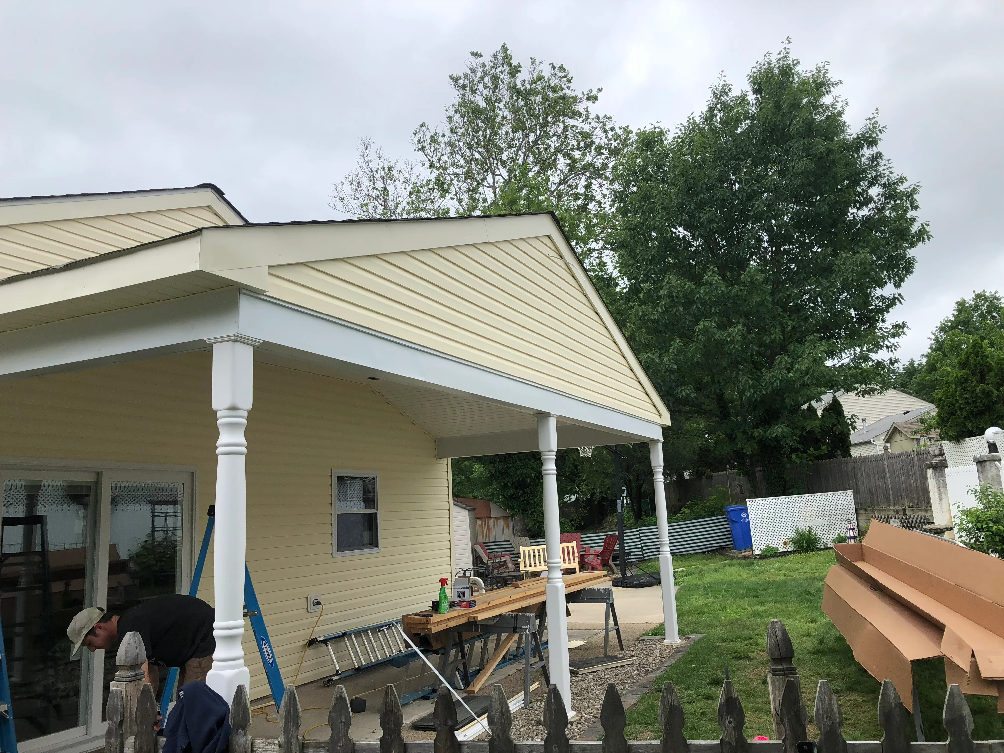 White vinyl porch addition with metal roof and columns on residential home