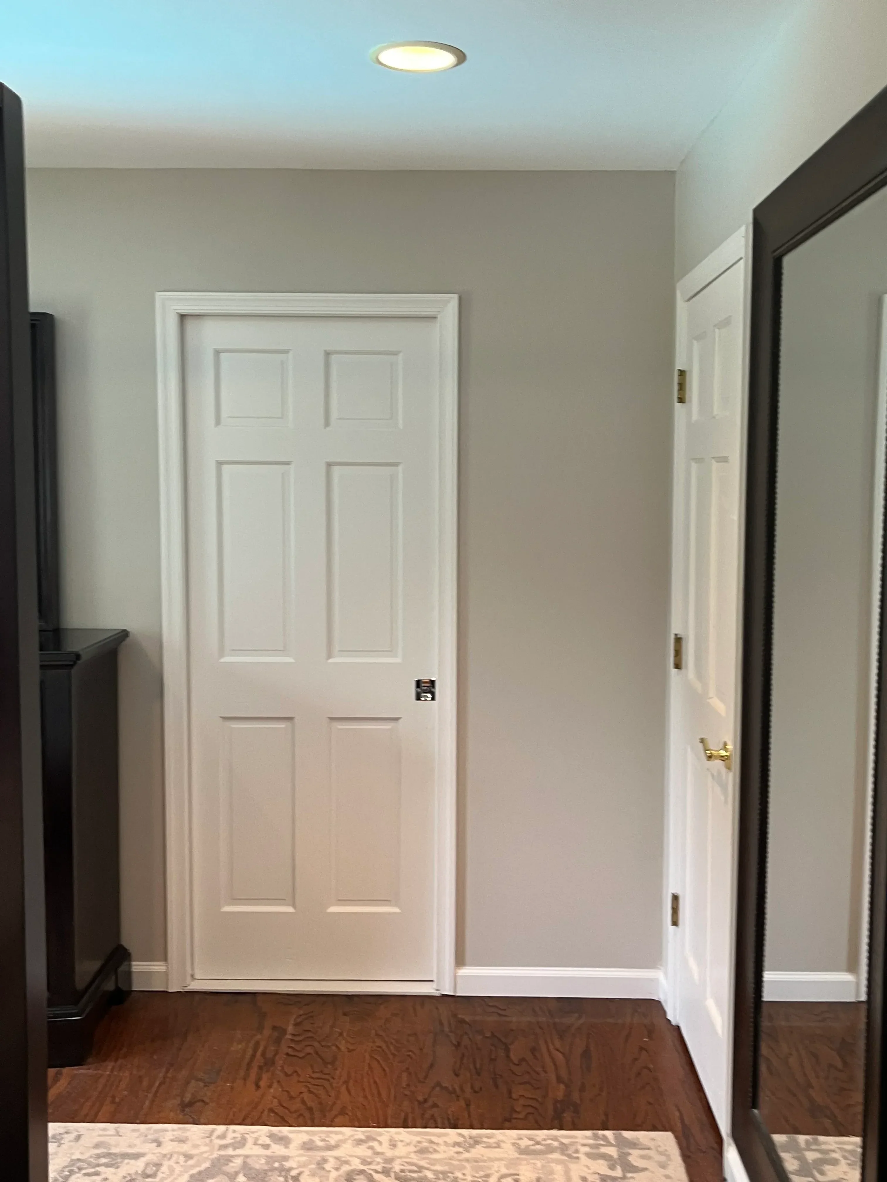 White raised-panel garage door with trim and hardware installation