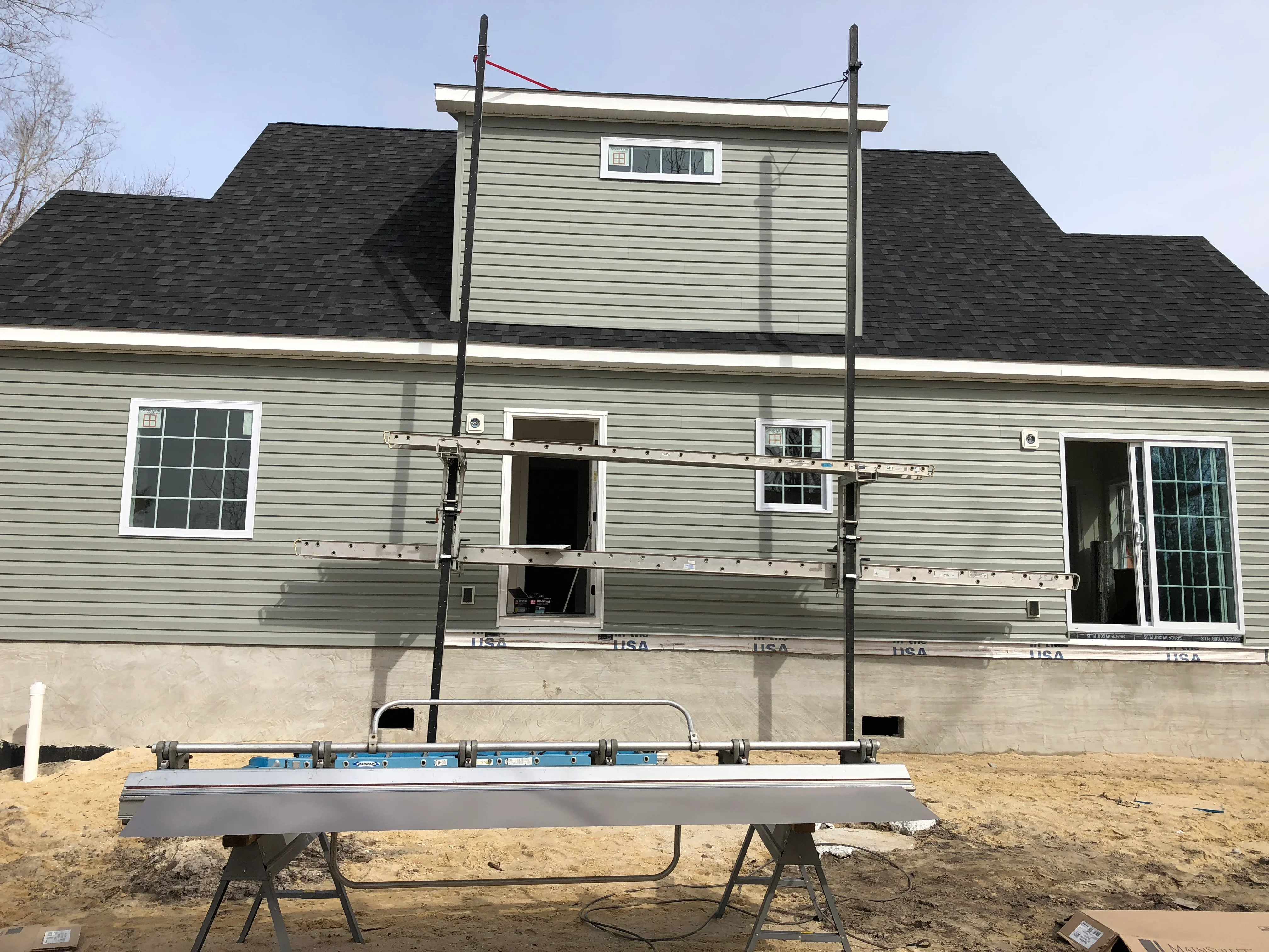 Vinyl siding installation with new windows and dark asphalt shingle roof on residential home