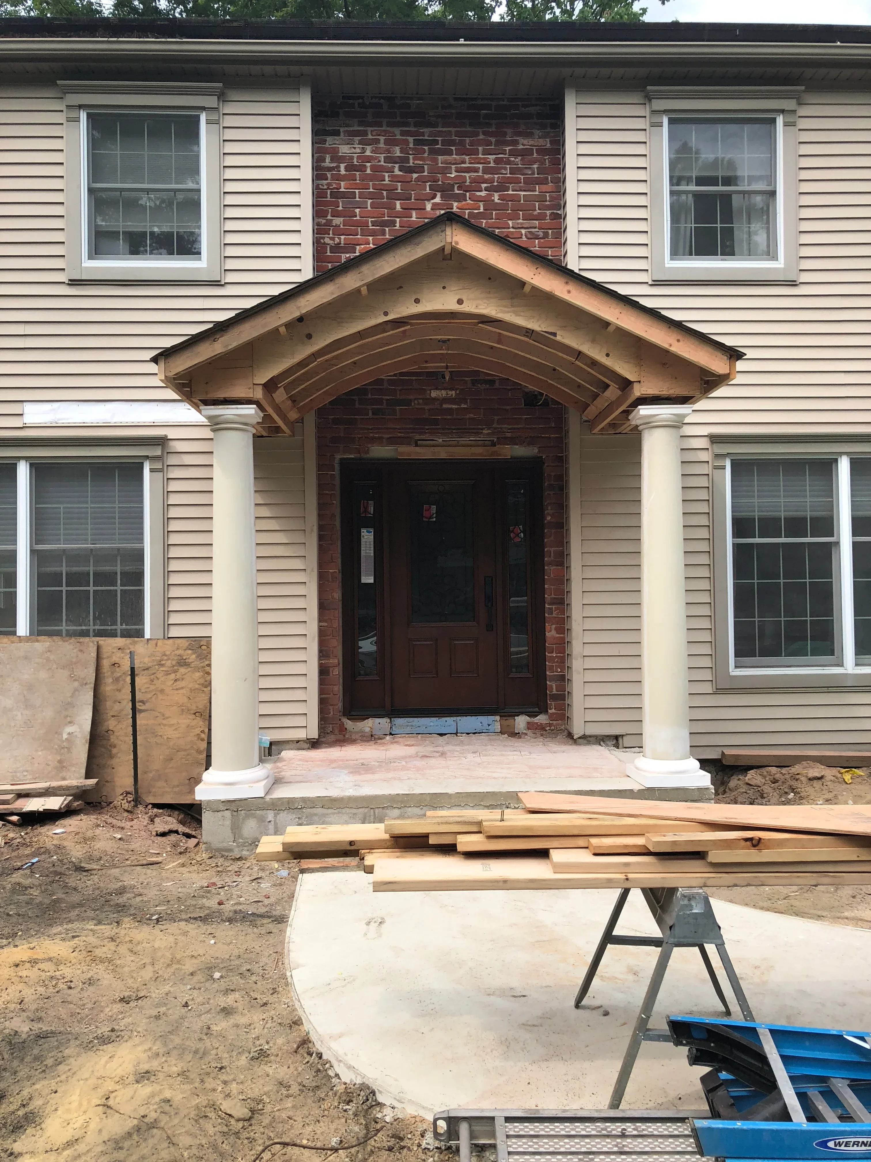 Metal corrugated siding with new aluminum windows and brick foundation on residential building